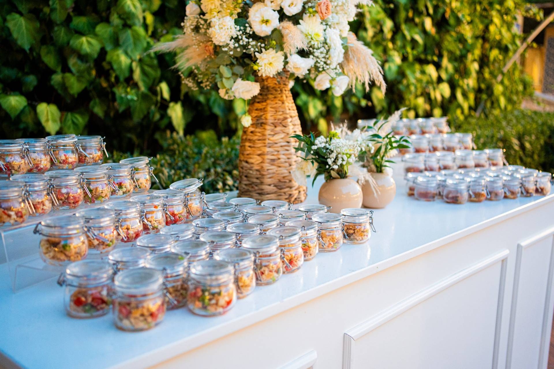 Buffet aperitivo con monoporzioni e vasetti di fiori