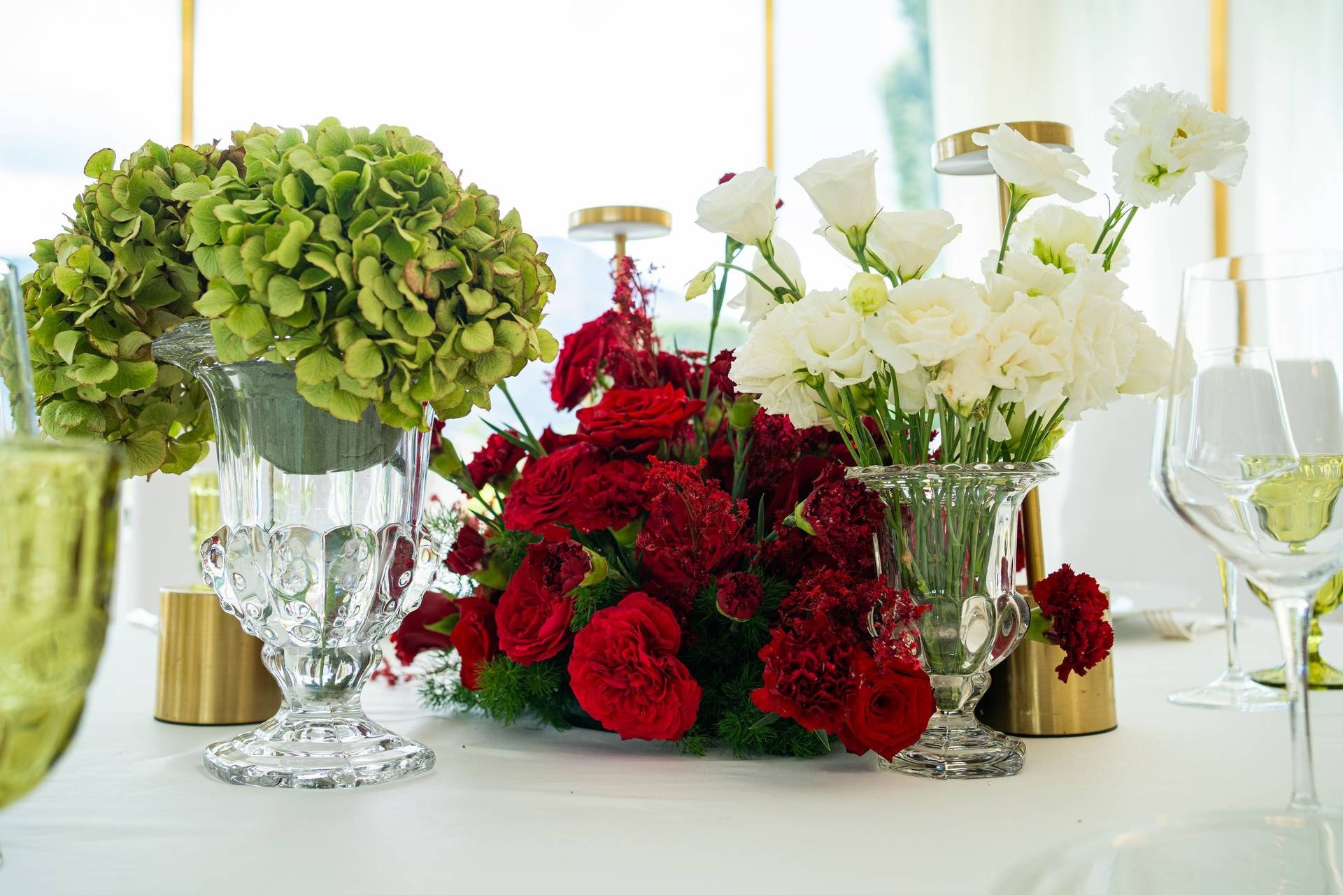 Composizione floreale con rose rosse e ortensie verdi