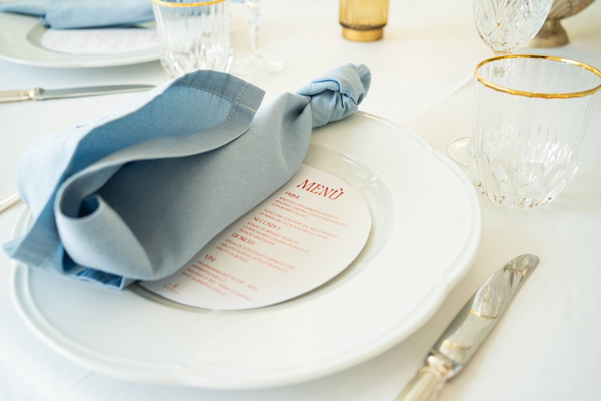 Mise en place con tovagliolo azzurro e menu