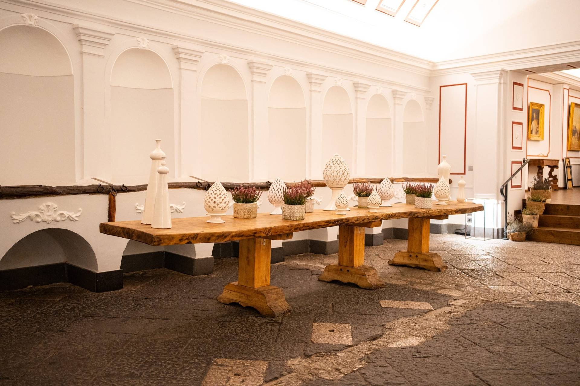Dettaglio tavolo in legno nella Sala Scuderia con decorazioni floreali