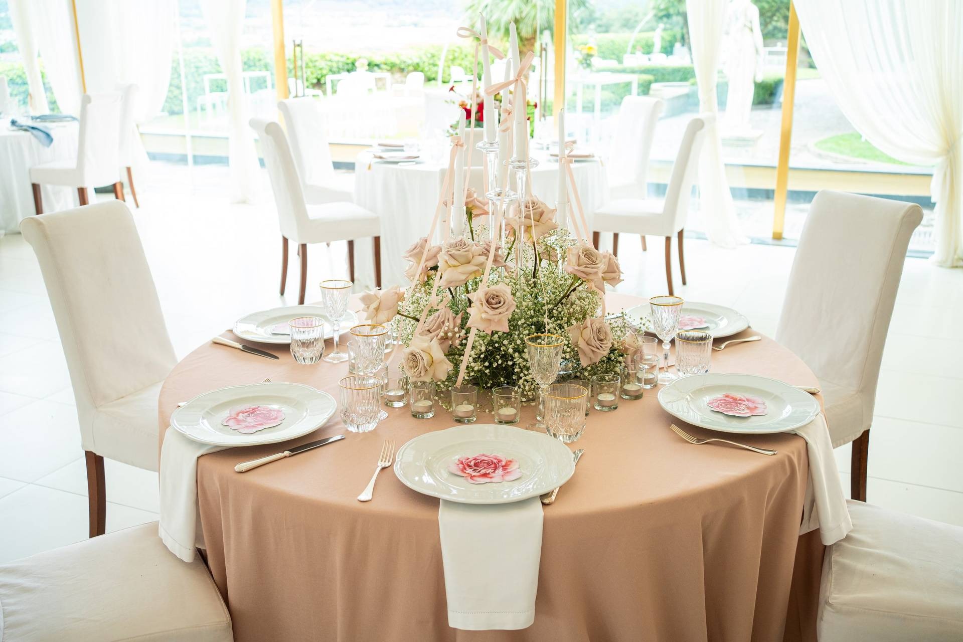 Allestimento matrimonio primaverile nella Sala Scuderia con tavoli rosa cipria e vetrate