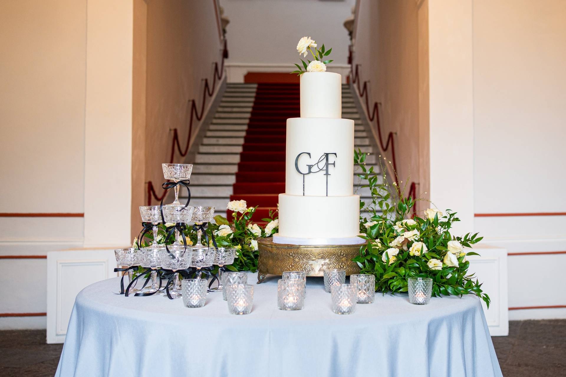 Torta nuziale con monogramma e piramide di champagne